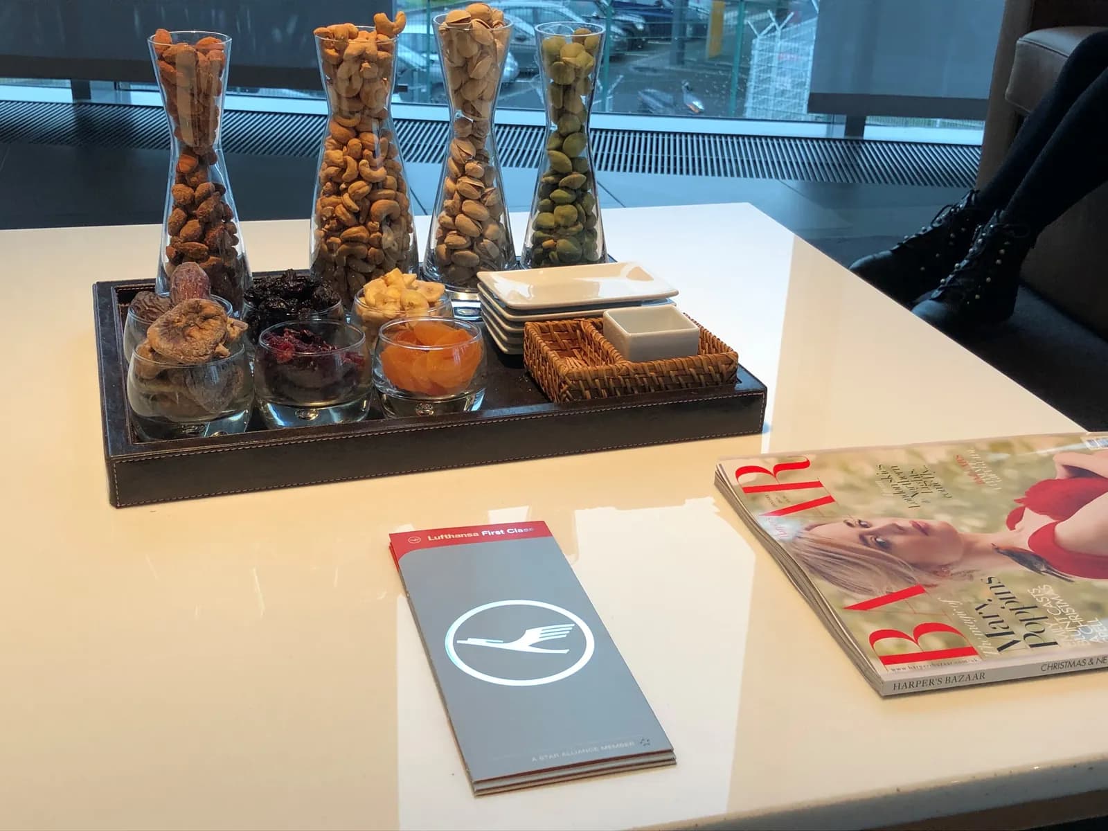 Bordkartenmappe, Nüsse und Zeitschriften im Lufthansa First Class Terminal