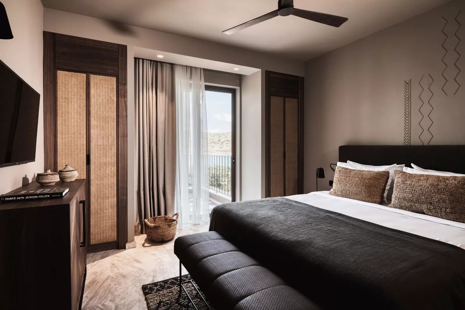 Schlafzimmer einer Suite mit Doppelbett und Balkontür