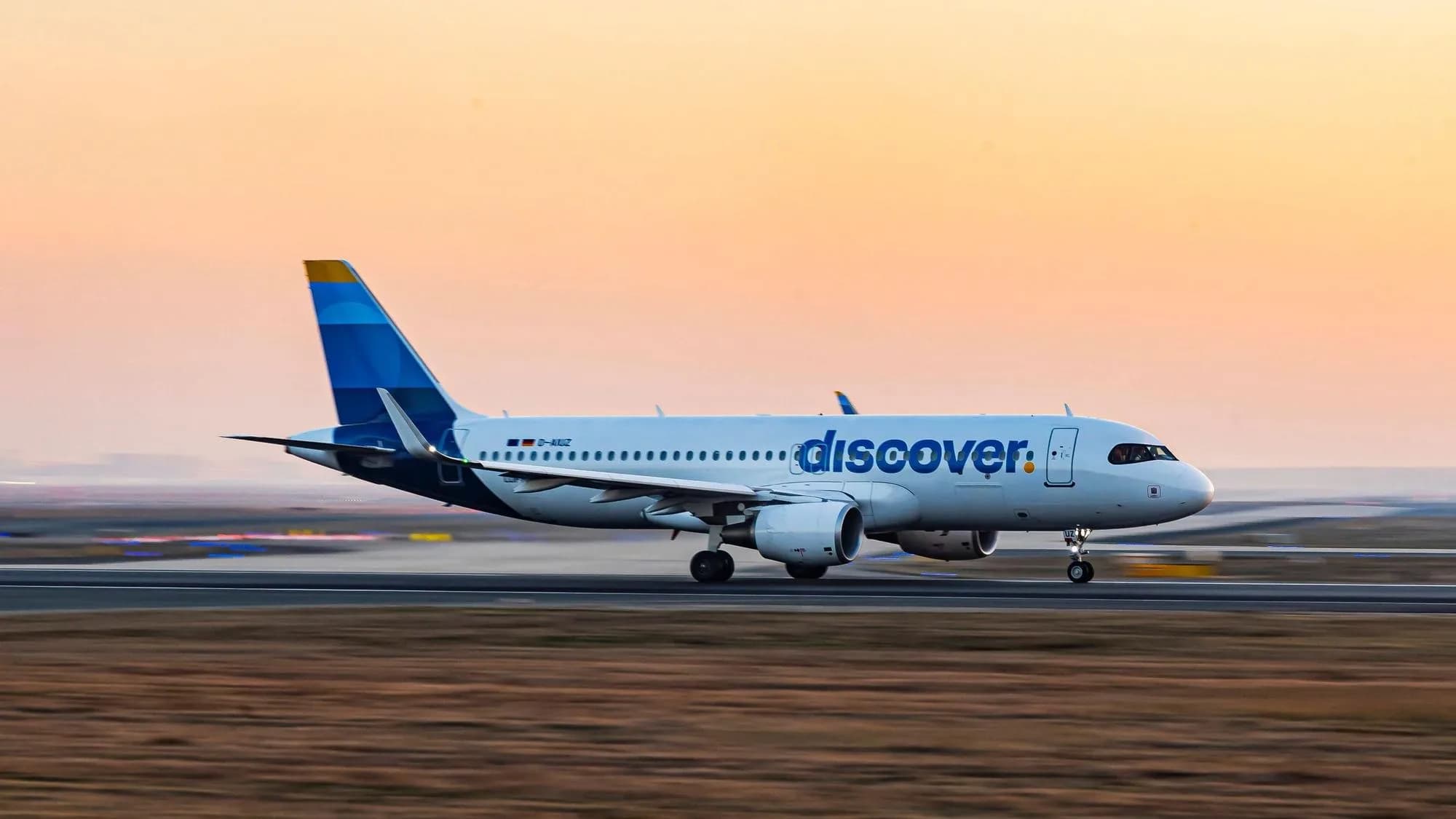 Airbus A320 von Discover Airlines beim Start im Abendlicht