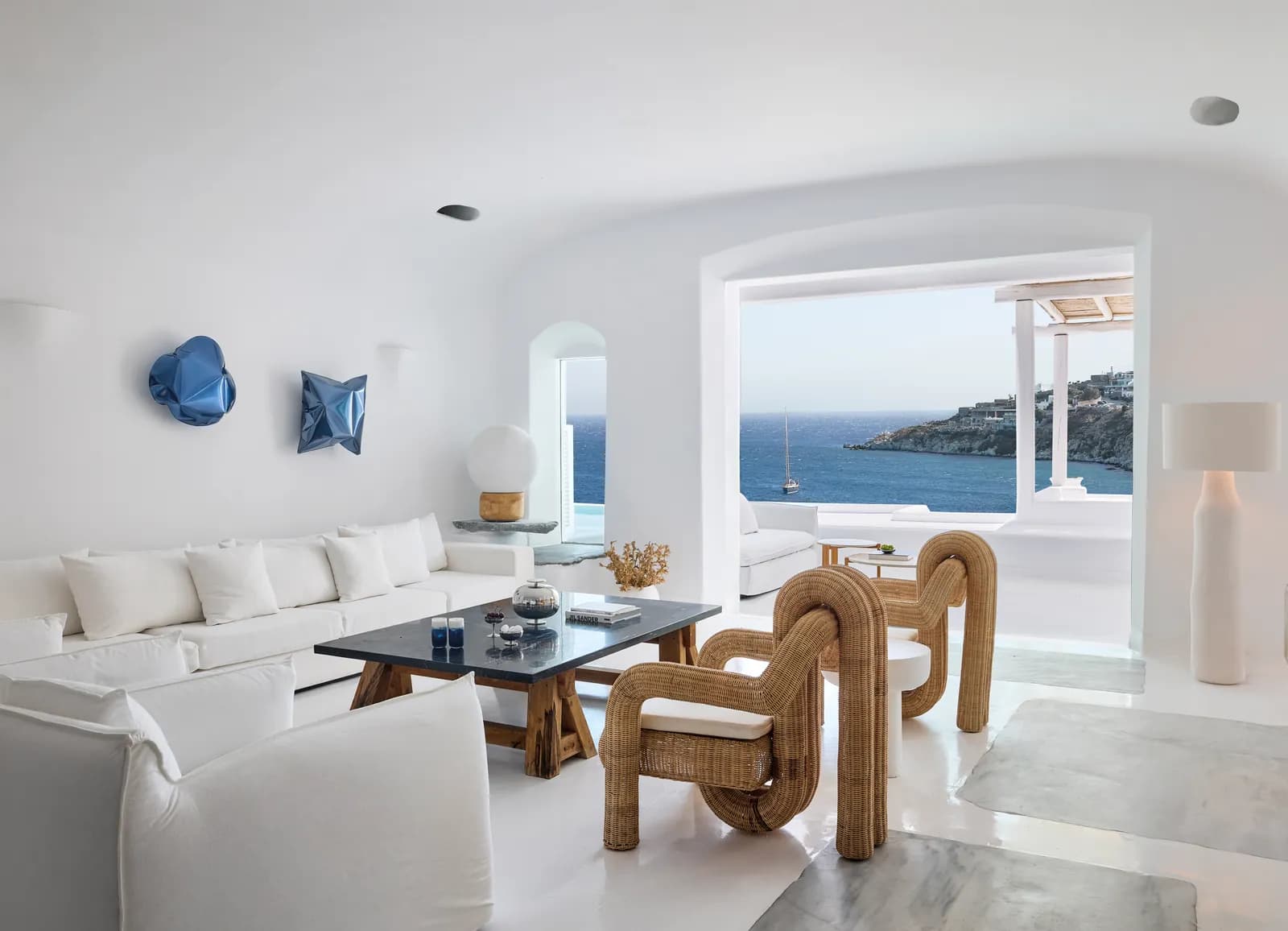 Wohnzimmer der Villa mit Sofa, Rattansesseln und Meerblick