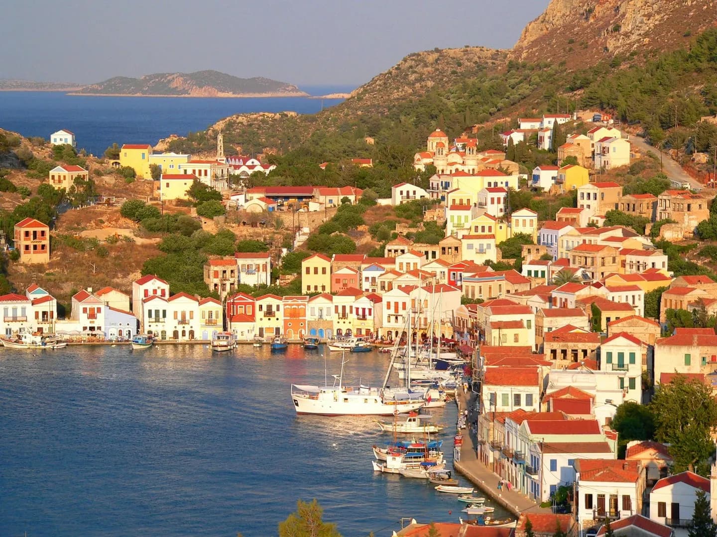 Der Hafen von Kastellorizo mit seinen farbigen Häusern im Abendlicht
